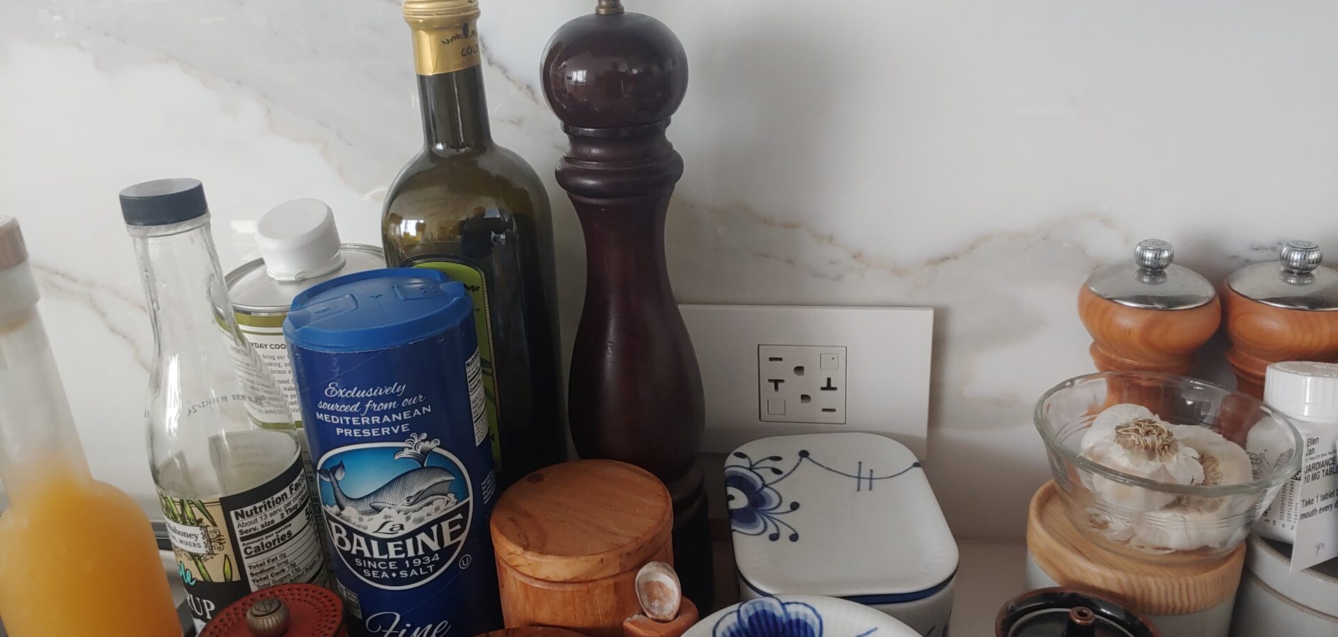 Condiments and cooking ingredients beside a white electrical socket
